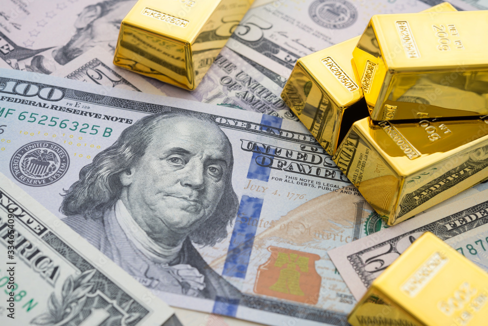 Gold bars on US dollar bill banknotes background. Concept of gold future trading, online asset commodity trading or buy gold bars for investment. It has been valued as a global currency, a commodity. Gold bars on US dollar bill banknotes background. Concept of gold future trading, online asset commodity trading or buy gold bars for investment. It has been valued as a global currency, a commodity.