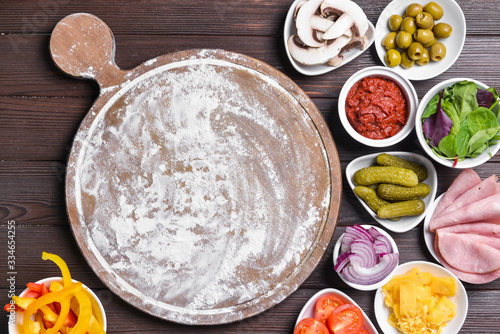 Ingredients for tasty pizza and board on wooden background