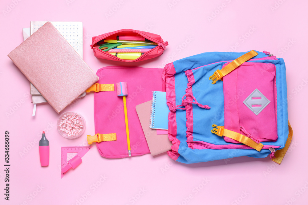School backpack and stationery on color background School backpack and stationery on color background