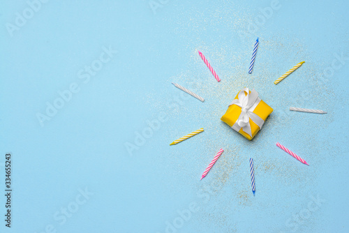 Birthday gift and candles on color background
