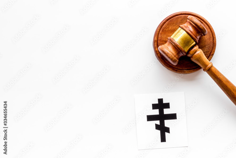 Ortodox cross - Christianity symbol - near gavel on white background top-down. Religious conflict concept. Copy space Ortodox cross - Christianity symbol - near gavel on white background top-down. Religious conflict concept. Copy space