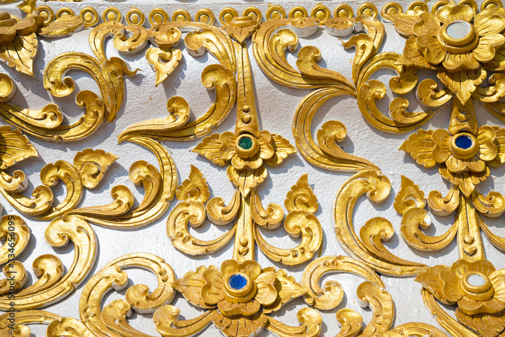 Detail texture background of beautiful painting low relief golden flower of pagoda decoration Lanna thai northern Thailand style, Chiangrai Thailand