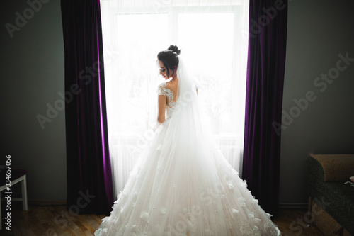 Gorgeous bride in robe posing and preparing for the wedding ceremony face in a room