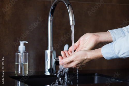 Closeup man is washing hands with soap for 20-30 seconds to prevent virus SARS-CoV-2, 2019-nCoV infection, that leads to respiratory illness. Personal hygiene and care. Coronavirus covid-19 pandemic.