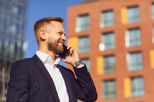 Businessman talking on the phone on the background of business building © Studio Romantic