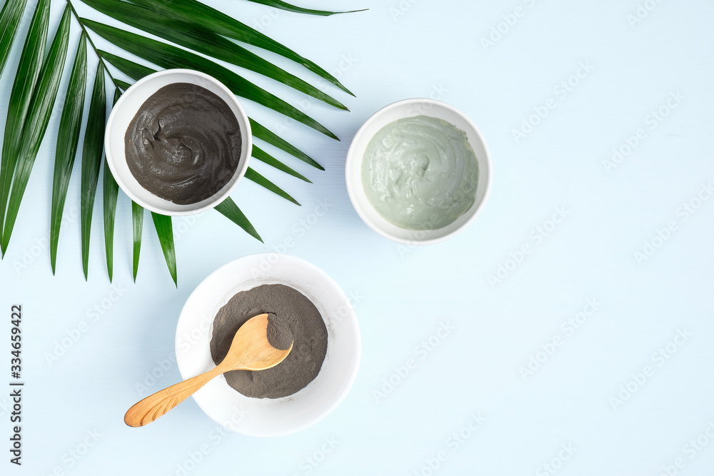 Flat lay facial clay mask and tropical leaf. Top view natural organic SPA cosmetic products for skincare, body and hair care concept Flat lay facial clay mask and tropical leaf. Top view natural organic SPA cosmetic products for skincare, body and hair care concept