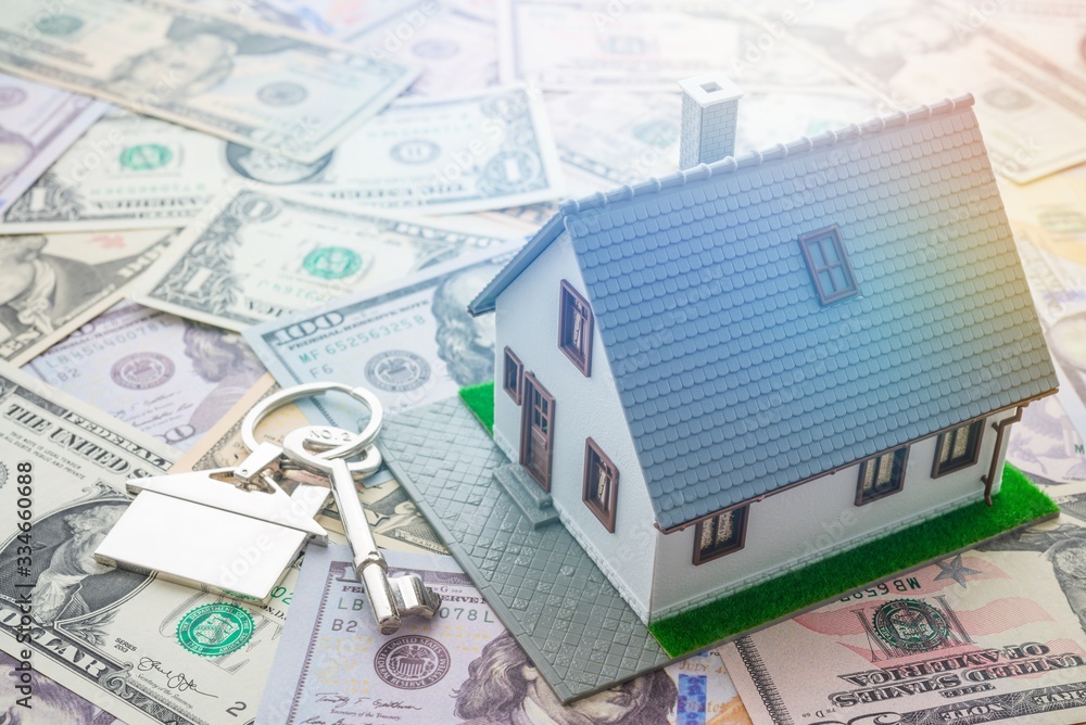 House model and home key on pile of money background. Money saving