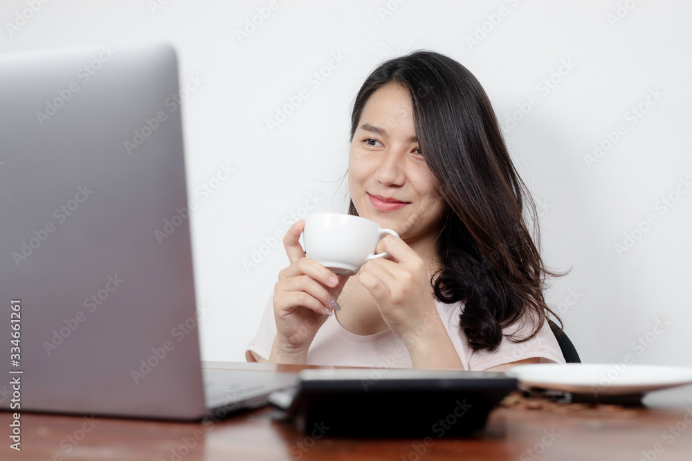 A beautiful Asian woman talking on the phone while sipping coffee. A beautiful Asian woman talking on the phone while sipping coffee.