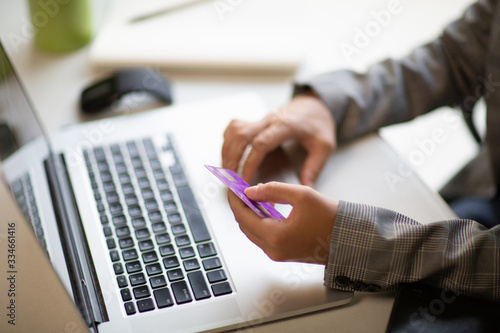 Young businesswoman holding a credit card and typing. On-line shopping on the internet using a laptop