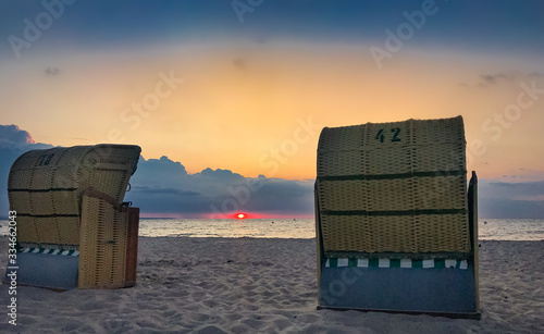 Two traditional Baltic beach chairs at the German Baltic Sea coast in the sunset photo