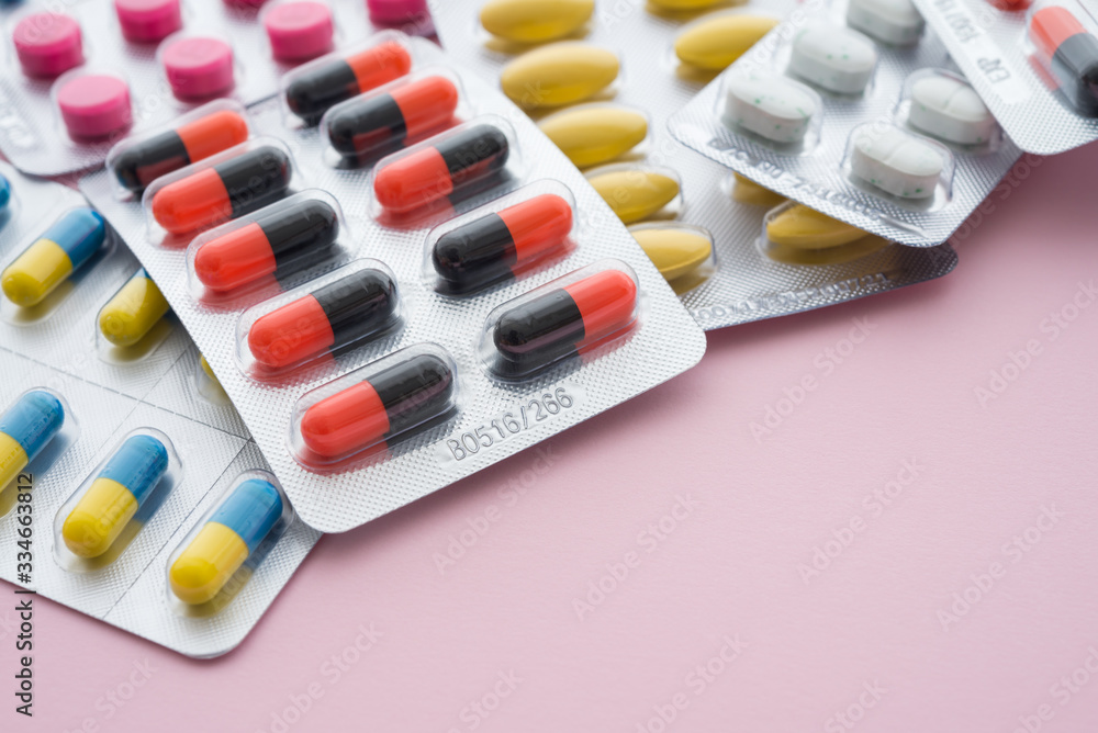 Healthcare, medical, buying medicine in drugstore or health insurance concept. Pharmaceuticals medicine pills and capsules pack on pink background and copy space. Healthcare, medical, buying medicine in drugstore or health insurance concept. Pharmaceuticals medicine pills and capsules pack on pink background and copy space.