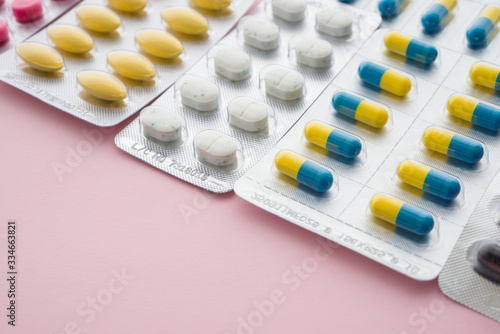 Healthcare, medical, buying medicine in drugstore or health insurance concept. Pharmaceuticals medicine pills and capsules pack on pink background and copy space.