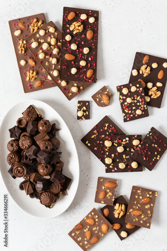 Variety of dark and milk chocolate bars and candies with nuts and dried fruits. Handmade organic chocolate. Top view