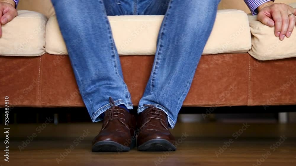 close up of man leg sitting on sofa close up of man leg sitting on sofa