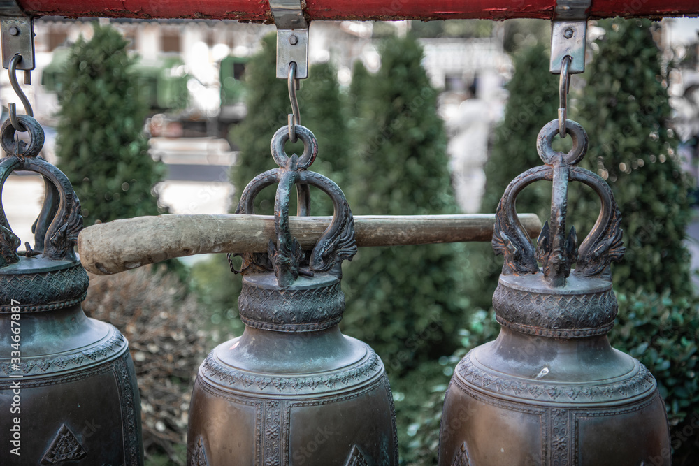 Fototapeta premium Bronze bells and a wooden stick
