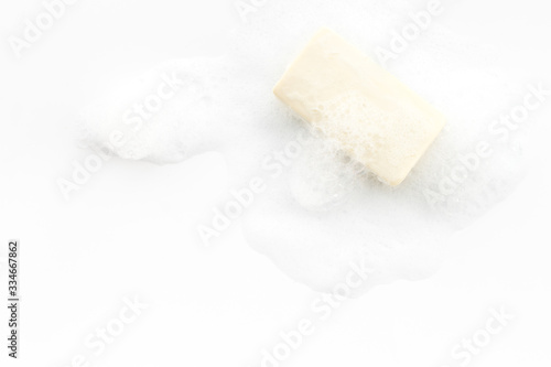 Soap bar with foam on white background top-down copy space
