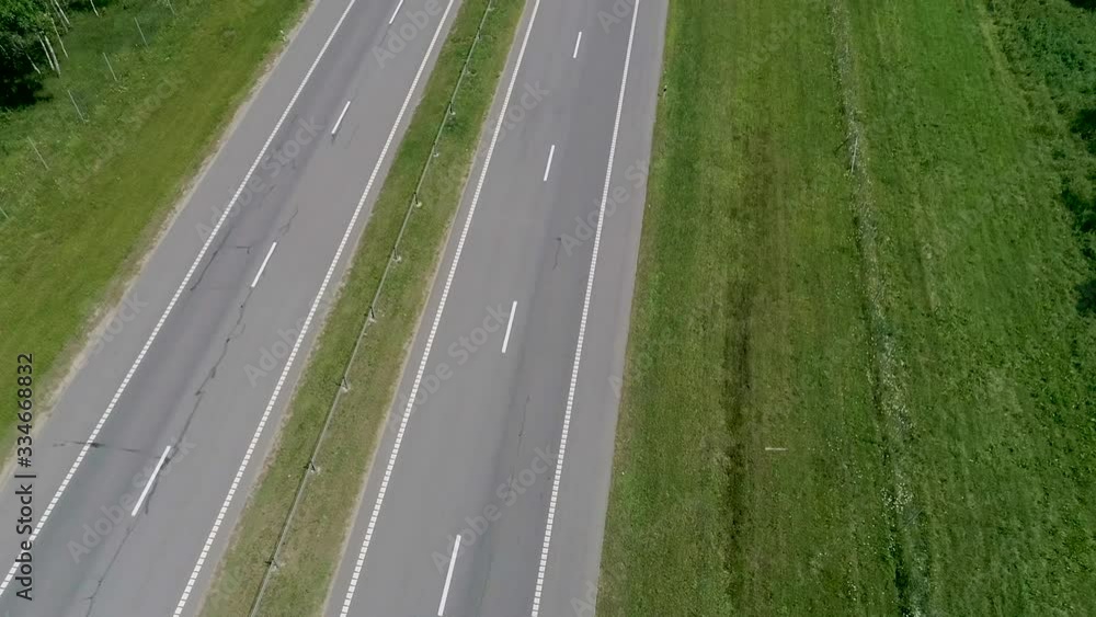 Trucks are driving along the road. A long highway through a forest area Trucks are driving along the road. A long highway through a forest area