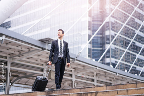 Wallpaper Mural Caucasian businessman confidently walking through the urban city district while holding and dragging along his black suit case, wearing formally black suit and tie with city skylines at the background Torontodigital.ca