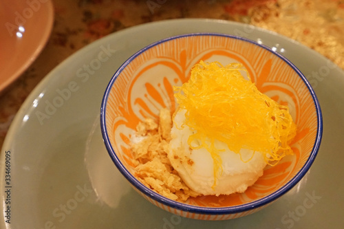 Close up Vanilla ice cream served with crumble and Fios de ovos (golden egg yolk floss thread)
