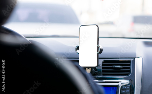 The phone is attached to the dashboard of the car with a white background for inserting text or images. front seat type