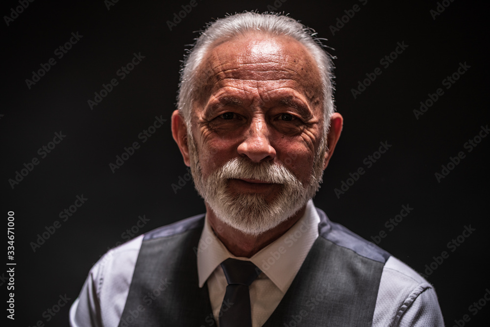 Portrait of smiling senior man on black background. Portrait of smiling senior man on black background.