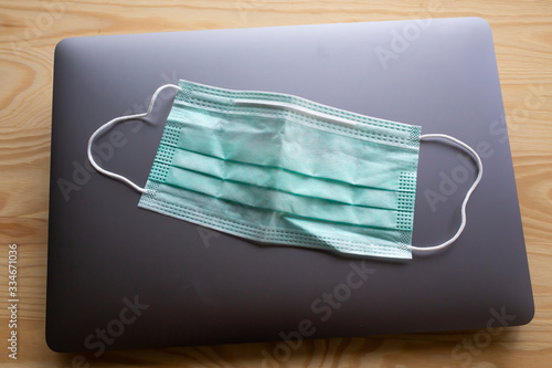 Face mask, Medical mask, Surgical mask on laptop, Wooden texture background, Close up shot, Selective focus, Prevention from covid19, Coronavirus, Bacteria, Healthcare