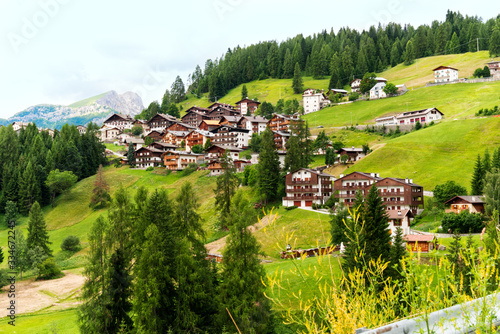 Mountain village houses in the Dolomites, Italy. Beautiful rural landscape in summer photo