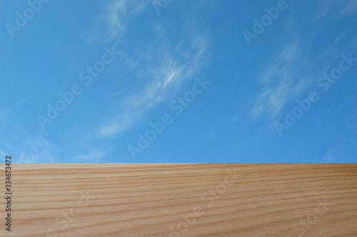 Wooden Board empty table in front of a blurry background. Perspective brown wood above a blurred sky background - can be used for demonstration or installation of your products.Mock up for displaying 