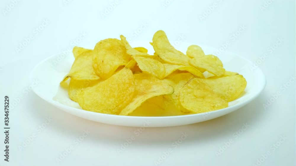Crispy potato chips on a white plate. 360 rotation. Crispy potato chips on a white plate. 360 rotation.