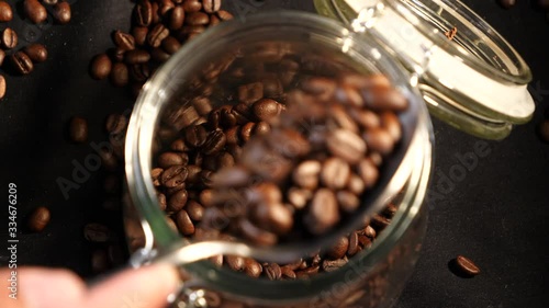 Coffee is put in a jar. Coffee beans. Coffee. Drink. The production of coffee. Close-up.