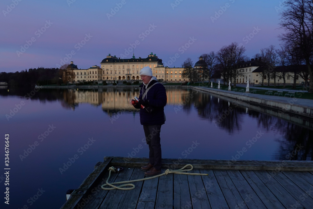 Fototapeta premium Stockholm, Sweden A man drinks thermos coffee at dawn at Drottningholm 