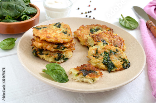 Pancakes with cabbage and spinach. Juicy vegetable cutlets on a plate with sour cream. Diet menu. Lenten dish.