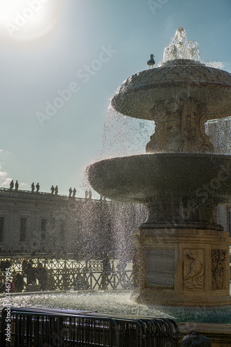 Zabytki na placu Św. Piotra w Watykanie. Na pierwszym planie ogromna fontanna, a w oddali widać bazylikę świętego Piotra, Włochy.