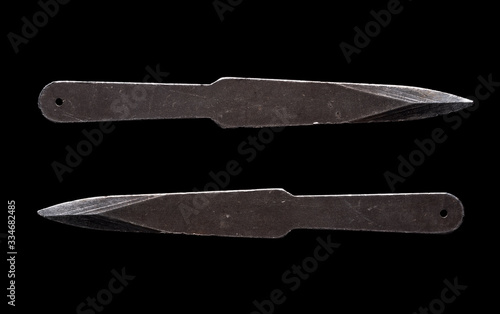 A pair of scratched steel throwing knives on black background (ID: 334682485)