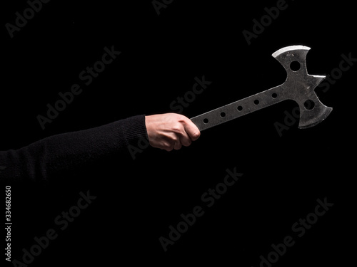 Woman's hand holding steel throwing axe on black background (ID: 334682650)