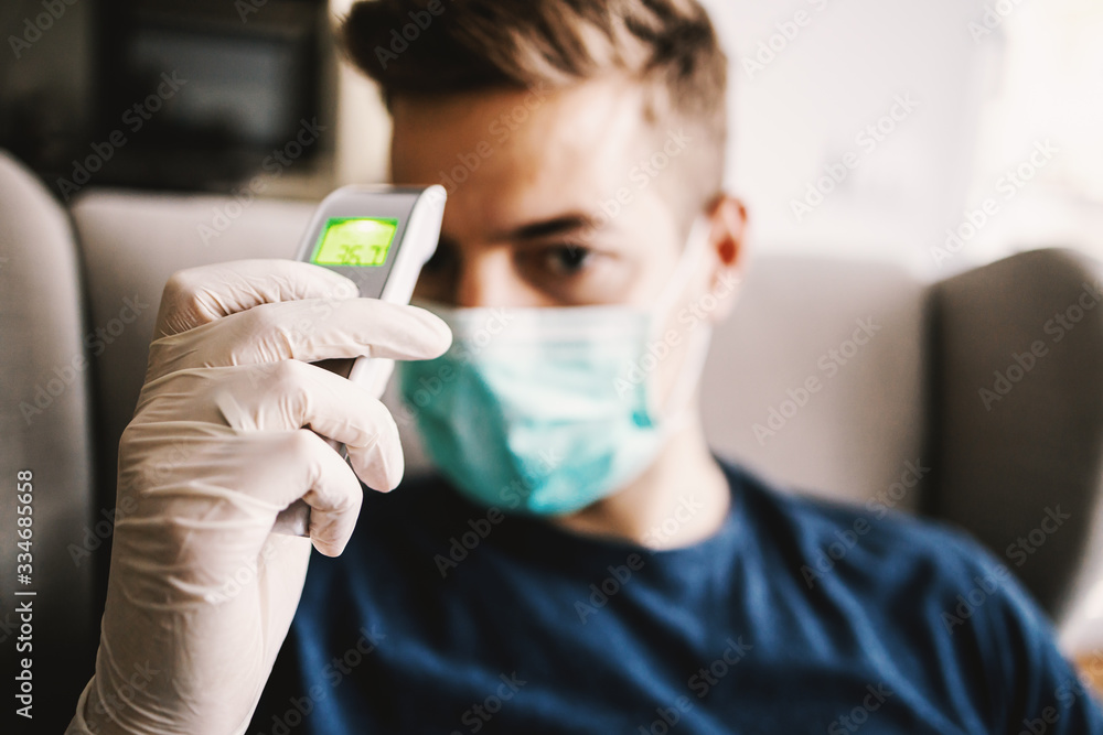Young man measuring temperature, world pandemic, stay at home. Young man measuring temperature, world pandemic, stay at home.
