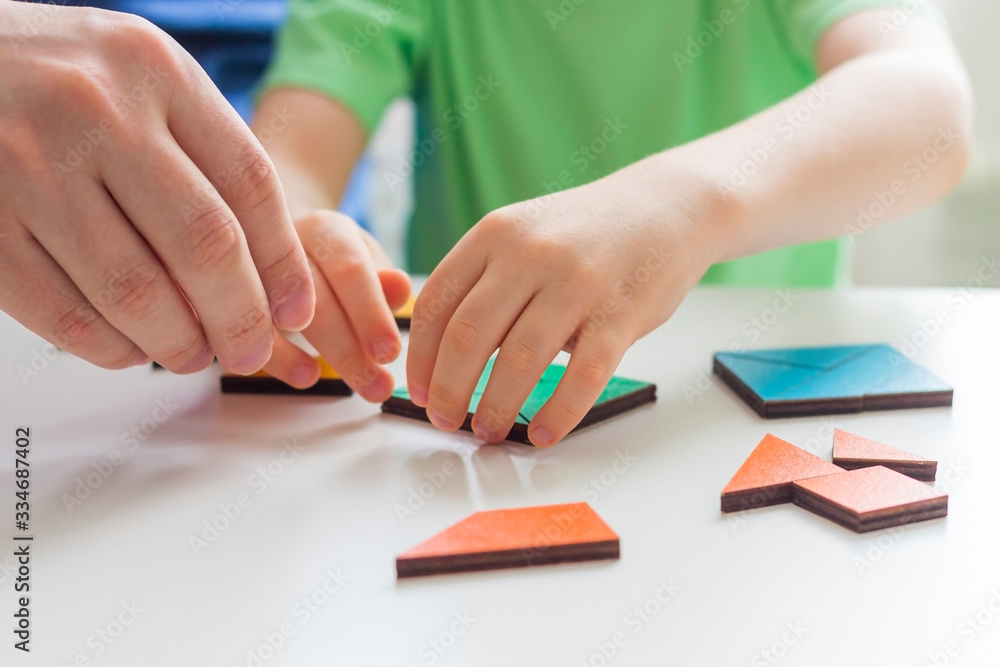 Stay at home, social distance and self-isolation during quarantine concept. Family leisure. Father and son playing logic games and wooden puzzles. Selective focus. Children's educational games Stay at home, social distance and self-isolation during quarantine concept. Family leisure. Father and son playing logic games and wooden puzzles. Selective focus. Children's educational games