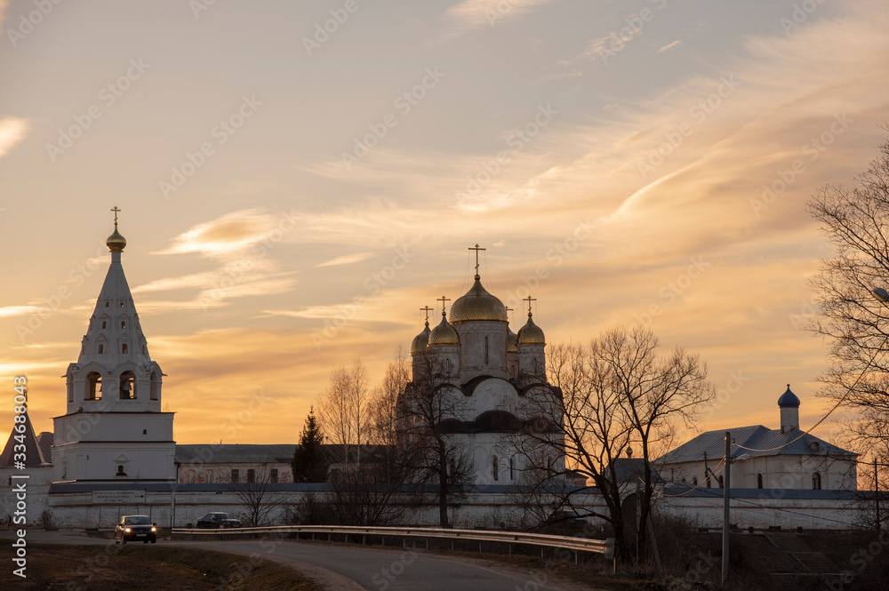 White stone wall and towers of the monastery against the background of the evening sky.