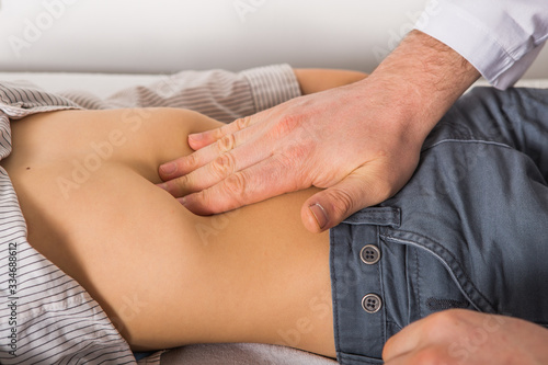 The doctor examines the belly child at clinic.