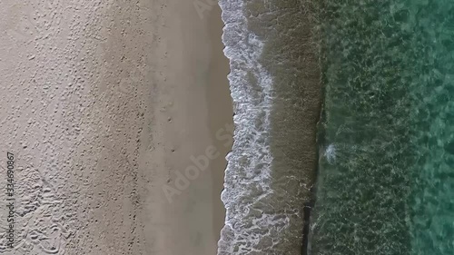 aerial view with drone of beach with white sand and crystal clear water and waves in the shore photo