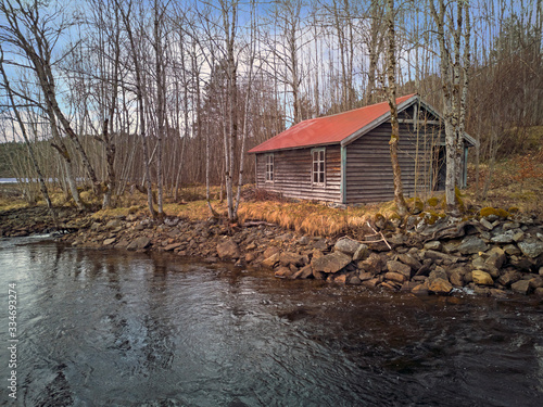 Cabin hut shed by river in woods