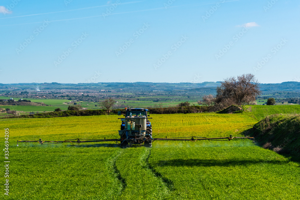 Fototapeta premium Tractor spraying crops