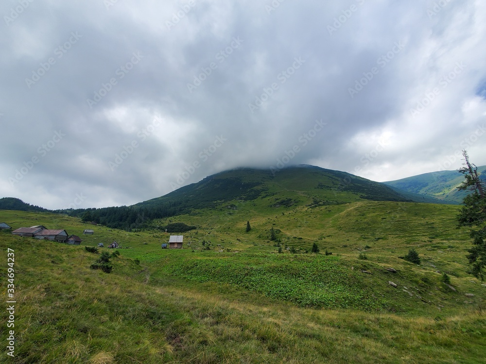A beautiful scenery of Carpathian mountains with small houses, trees, fields, and roads in the summertime. A beautiful scenery of Carpathian mountains with small houses, trees, fields, and roads in the summertime.