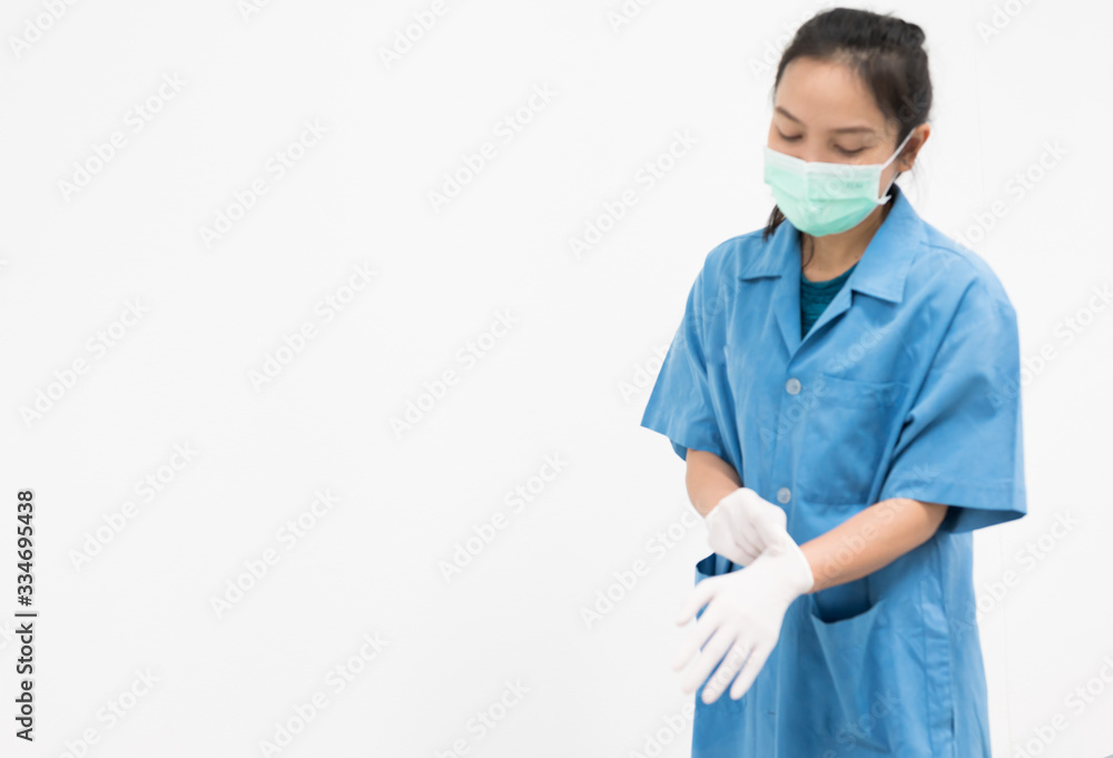 Woman doctor putting blue latex medical gloves on white background.Surgeon wearing gloves before surgery at operating room.Risk and infection control concept. Woman doctor putting blue latex medical gloves on white background.Surgeon wearing gloves before surgery at operating room.Risk and infection control concept.