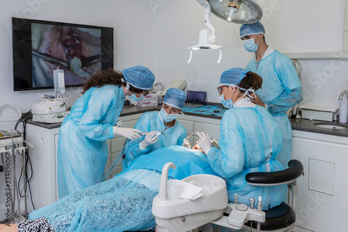 Dentist performing teeth surgery on patient