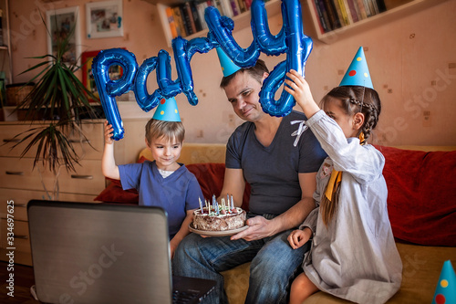 Happy father with two sibling celebrating birthday via internet in quarantine time, self-isolation