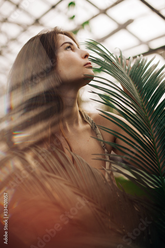 portrait of a beautiful stylish girl in a green batanic garden photo