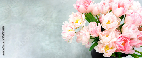An elegant card with a bouquet of pink tulips on a light gray background with copy space for congratulatory text and wishes. A luxurious bouquet of tulips as a gift for Easter, mother's day, wedding.