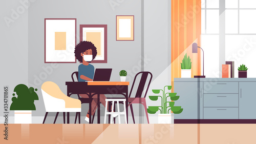 african american woman in protective mask using laptop coronavirus pandemic quarantine concept work from home online education freelance modern living room interior full length horizontal vector