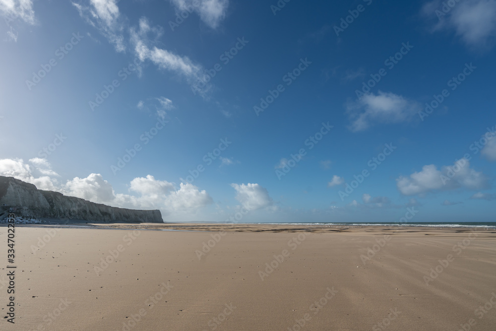 Beach near Cap Blanc Nez in northern France at the Cote d'Opale on a sunny day with smooth sand and cliffs in the background.